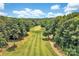 Beautiful aerial view of a lush golf course surrounded by mature trees and rolling hills at 1077 Gauguin Ln, Tega Cay, SC 29708