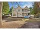 Backyard view showcasing a two-story home with a balcony and covered patio, blending indoor/outdoor living at 11911 Farnborough Rd, Huntersville, NC 28078