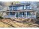Two-story gray house with a wraparound porch and rocking chairs at 1316 Neal Hawkins Rd, Gastonia, NC 28056