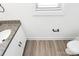 This bathroom features a granite countertop, modern white cabinet, a toilet, and wood-look vinyl flooring at 204 N Yadkin Ave, Spencer, NC 28150