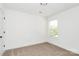 This bedroom features carpet flooring, white walls, and a window for natural light at 204 N Yadkin Ave, Spencer, NC 28150