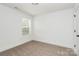 This bedroom features carpet flooring, white walls, a window for natural light, and a closet at 204 N Yadkin Ave, Spencer, NC 28150