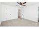 Bright bedroom featuring neutral carpet, ceiling fan, and white trim at 204 N Yadkin Ave, Spencer, NC 28150