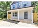 Inviting front porch with classic columns leading to a gray front door of this charming home at 204 N Yadkin Ave, Spencer, NC 28150