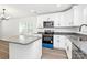 Well-lit modern kitchen featuring sleek white cabinets, stainless steel appliances, and granite countertops at 204 N Yadkin Ave, Spencer, NC 28150