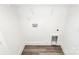 This laundry features a utility sink, washer hookups, dryer hookups, wood-look vinyl flooring, and white walls at 204 N Yadkin Ave, Spencer, NC 28150