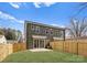 Back exterior view of a newly constructed home with a fenced in yard and sliding glass door at 2221 Edison St, Charlotte, NC 28206