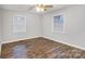 Simple bedroom with hardwood floors and two windows with blinds at 27097 Cove Ln, Tega Cay, SC 29708