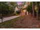 House exterior with a sloped driveway and a brick retaining wall; located in a wooded area at 27097 Cove Ln, Tega Cay, SC 29708