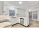 Efficient kitchen featuring white cabinets, dishwasher, and access to dining area at 27097 Cove Ln, Tega Cay, SC 29708