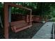 Cozy wooden bench swing with a deck in the background, perfect for relaxing outside at 4816 Zion Church Rd, Concord, NC 28025