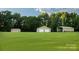 Property featuring shed with wreaths, garage and carport, all surrounded by lush green lawn at 4816 Zion Church Rd, Concord, NC 28025