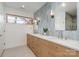 Spacious bathroom featuring a double sink vanity, modern fixtures, light blue tile and a window at 4833 Addison Dr, Charlotte, NC 28211