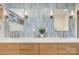 Well-lit bathroom with light blue tiling, double sinks, a white countertop and contemporary fixtures at 4833 Addison Dr, Charlotte, NC 28211