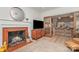 Living room fireplace with vintage brick surround and hardwood floors with open-concept kitchen in the background at 4833 Addison Dr, Charlotte, NC 28211