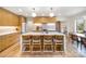 Spacious kitchen with an island featuring seating, sleek wooden cabinets, and modern light fixtures at 4833 Addison Dr, Charlotte, NC 28211