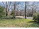 A glimpse of the street view, showcasing the verdant surroundings and mature trees of the property at 4833 Addison Dr, Charlotte, NC 28211