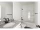 Bathroom featuring granite countertops, a white sink, white bathtub with shower, black fixtures, and wood-look floors at 5177 Flay Rd, Lincolnton, NC 28021