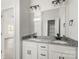 Bright bathroom featuring a double vanity with granite countertop and modern fixtures, plus a walk-in closet in the background at 5177 Flay Rd, Lincolnton, NC 28021