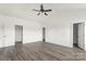 Large bedroom featuring dark wood-look floors, white walls and trim, vaulted ceiling, and three doors at 5177 Flay Rd, Lincolnton, NC 28021