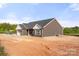 Angle view of the exterior elevation featuring gray siding and a two-car garage at 5177 Flay Rd, Lincolnton, NC 28021