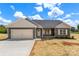 Charming single-story home featuring a neutral color scheme, attached garage, and beautifully landscaped front yard on a sunny day at 5177 Flay Rd, Lincolnton, NC 28021