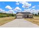 Charming single-story home featuring a two-car garage, gray siding, and a concrete driveway, set against a blue sky backdrop at 5177 Flay Rd, Lincolnton, NC 28021