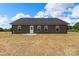 Rear view of a single story home with gray siding and a concrete patio, showcasing the well-maintained backyard space at 5177 Flay Rd, Lincolnton, NC 28021
