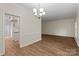 Open concept dining area next to kitchen featuring wood floors and an elegant chandelier at 5929 Quail Hollow Rd # B, Charlotte, NC 28210