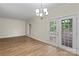 Dining area with hardwood floors, bright chandelier, and doors leading to an outdoor space at 5929 Quail Hollow Rd # B, Charlotte, NC 28210