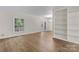 Bright living room with wood floors, large window, built-in shelving, and double glass doors at 5929 Quail Hollow Rd # B, Charlotte, NC 28210