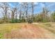 View of the backyard includes a truck parked on a pad, and mature trees at 65 Franklin St, Wadesboro, NC 28170