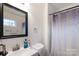 Bathroom showcasing a vanity, mirror, and shower with patterned curtain at 65 Franklin St, Wadesboro, NC 28170