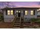 Charming one-story home with white siding, black shutters and inviting wooden stairs to front door at 65 Franklin St, Wadesboro, NC 28170