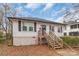 Charming one-story home with white siding, black shutters and inviting wooden stairs to front door at 65 Franklin St, Wadesboro, NC 28170