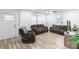 Inviting living room featuring a comfortable brown sofa set, light wood floors, and natural light from two windows at 65 Franklin St, Wadesboro, NC 28170