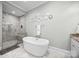 Luxurious bathroom with a freestanding tub, walk-in shower, and stylish marble tile, creating a spa-like experience at 736 Amalfi Dr, Davidson, NC 28036