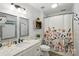 Bathroom with a floral shower curtain, dual mirrors, white marble vanity, and plant accents at 9108 Nolley Ct # B, Charlotte, NC 28270