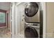 Laundry area with stacked washer and dryer set, and shelving for storage in a closet at 9108 Nolley Ct # B, Charlotte, NC 28270