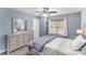 This bedroom features soft, blue walls, a ceiling fan, and light wood dresser at 101 Arbridge Ct, Mount Holly, NC 28120