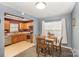 Cozy dining area features a wooden table, four chairs, and natural light from the nearby kitchen and window at 101 Arbridge Ct, Mount Holly, NC 28120