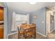 Bright dining area with a wooden table set for two, large window, and gray carpet at 101 Arbridge Ct, Mount Holly, NC 28120