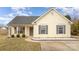 Attractive one-story home with yellow siding, gray shutters, and a manicured front yard at 101 Arbridge Ct, Mount Holly, NC 28120