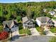 An aerial view of a well-kept gray two-story home with a two-car garage surrounded by lush trees at 10120 Garman Hill Dr, Charlotte, NC 28214