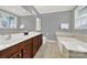 Bright bathroom with double sinks, a soaking tub, and a separate toilet area at 10120 Garman Hill Dr, Charlotte, NC 28214