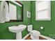 Stylish half bathroom with a decorative mirror, green paint and modern fixtures at 10120 Garman Hill Dr, Charlotte, NC 28214