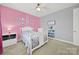 Bright bedroom features pink walls, white furniture, and natural light from the large window at 10120 Garman Hill Dr, Charlotte, NC 28214