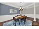 Elegant dining room with a wooden table, stylish chairs, wainscoting, and a modern chandelier at 10120 Garman Hill Dr, Charlotte, NC 28214