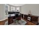 Home office with dark wood desk and cabinetry, bay window and hardwood floors at 10120 Garman Hill Dr, Charlotte, NC 28214