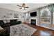 Cozy living room with a fireplace, large windows, and a ceiling fan at 10120 Garman Hill Dr, Charlotte, NC 28214